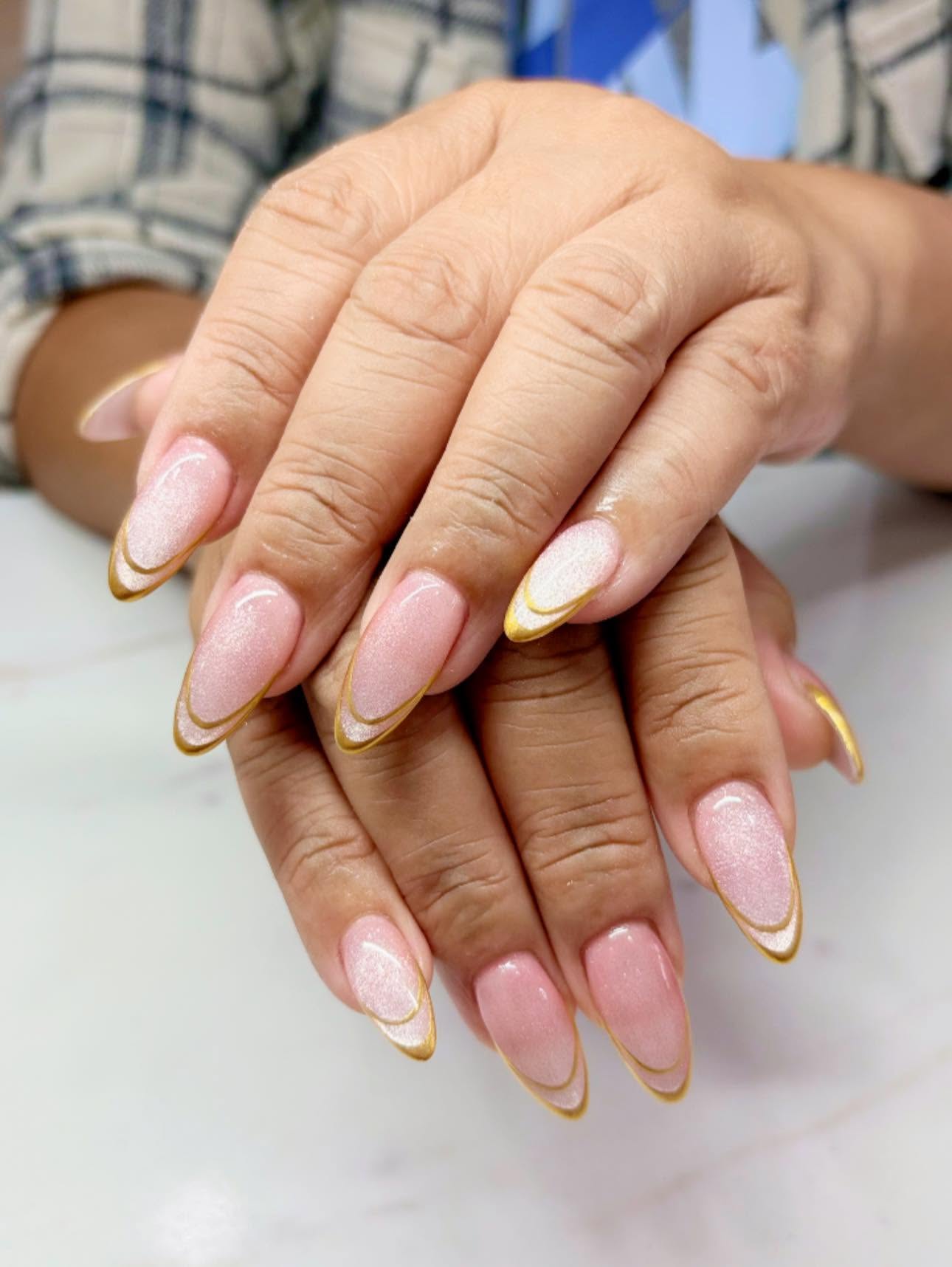 Gold outlined pink manicure created at Creative Nails & Spa