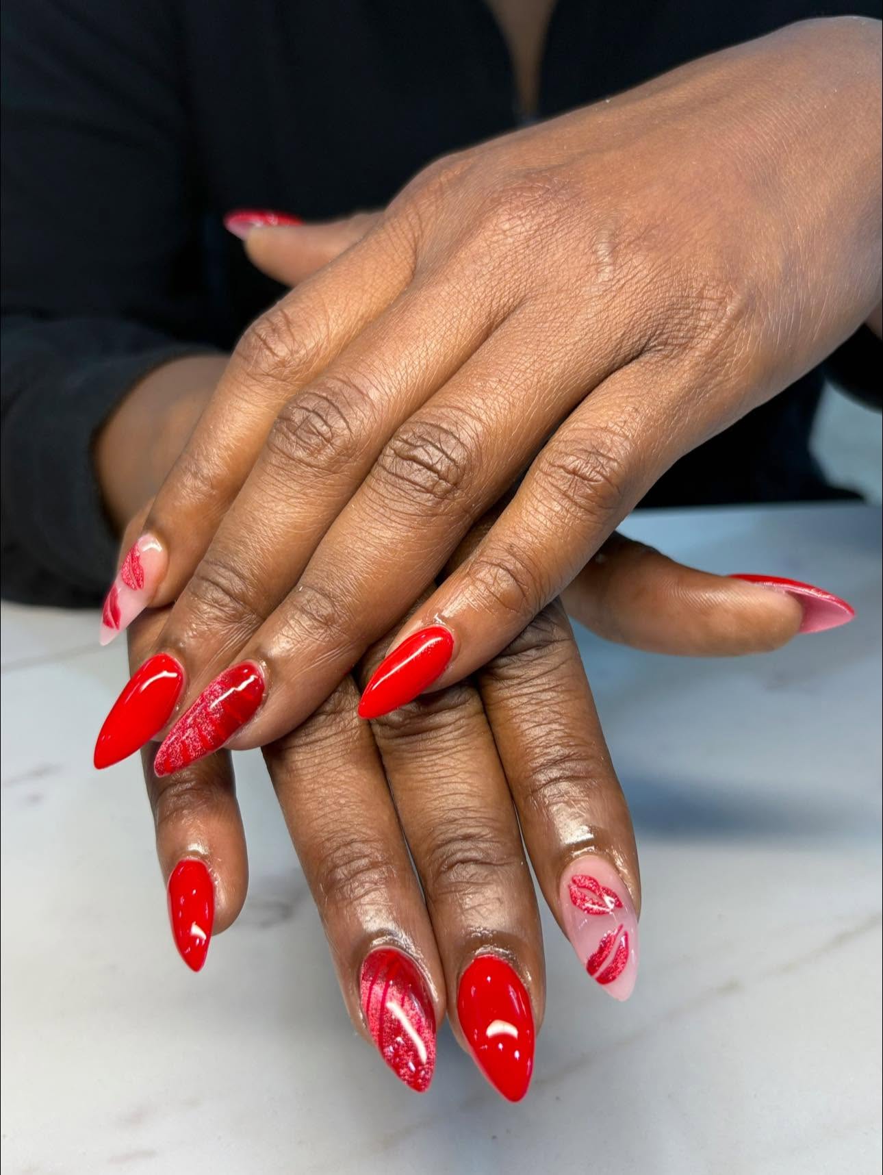 Glossy red almond nails with lip-print accents